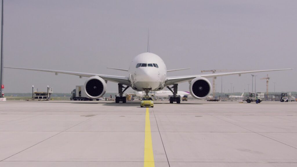 The Mini Electric towing a Boeing 777 plane as part of a publicity stunt